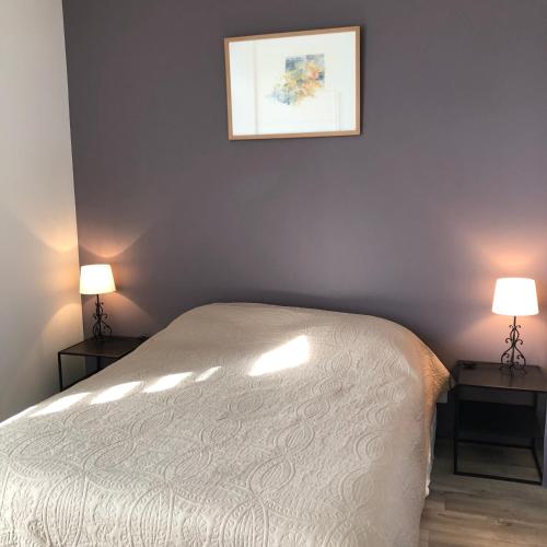 a bedroom with a bed and two lamps on two tables at Le Logis du GAST Chambre Taupe in Le Gast
