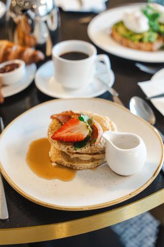 a plate with a sandwich and a cup of coffee at Hotel Collingwood BW Signature Collection in Bournemouth