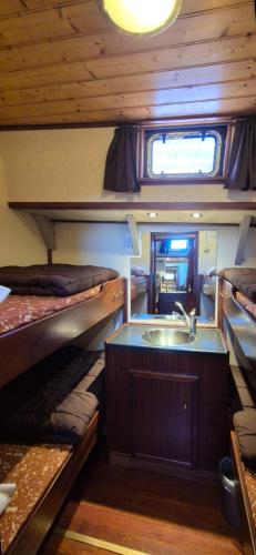 a room with two bunk beds and a sink at Klipper Stella Frisia in Akkrum