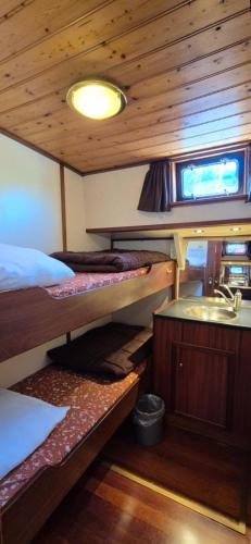 a room with two bunk beds and a sink at Klipper Stella Frisia in Akkrum