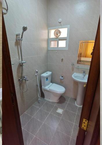 a bathroom with a toilet and a sink at Aknan Al Saada in Salalah