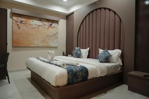 a bedroom with two beds with a large headboard at Hotel The Avanta- Naroda in Naroda