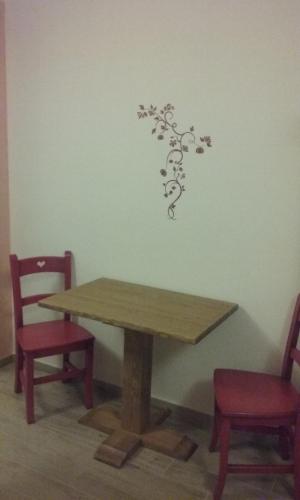a table with two chairs and a wall with a tree sticker at Camera Fenis in Fenis