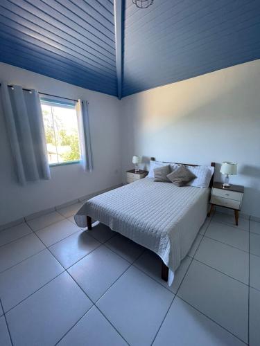 a white bedroom with a bed and a window at Recanto dos Valles in Búzios