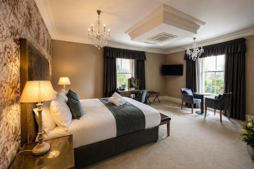 a bedroom with a large bed and a dining room at Y Seren Hotel & Restaurant in Carmarthen