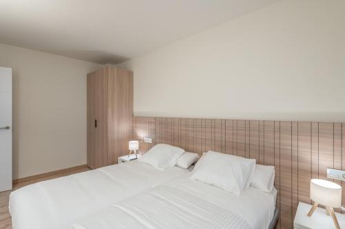 a white bed with white pillows in a bedroom at Be1960 quart in Bagá