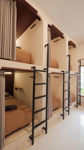 a room with bunk beds in a hostel at Nira Hostel Kuta Lombok in Kuta Lombok