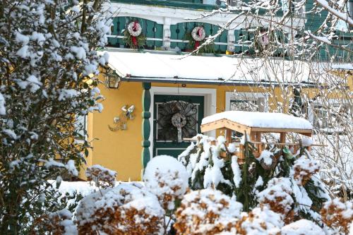 a house with a green door in the snow at Gästehaus Fuchs in Gröbming