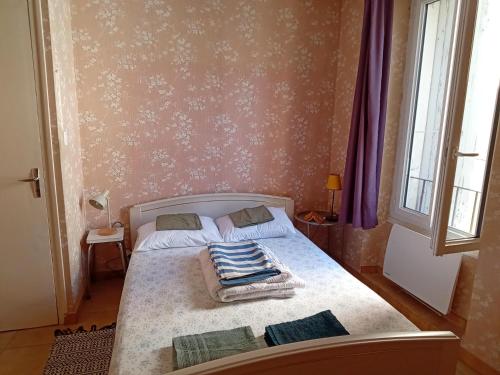 a bedroom with a bed with a blanket on it at Appartement 2chb et balcon au centre de Nyons in Nyons