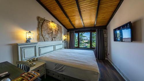 a bedroom with a large bed and a window at Assos Behram Special Class Hotel Adults Only in Behramkale