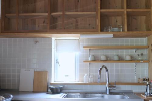 a kitchen with a sink and a window at Lotus Retreat ロータスリトリート 高知空港から車で30分 山のふもとの一棟貸しコテージ in Kami