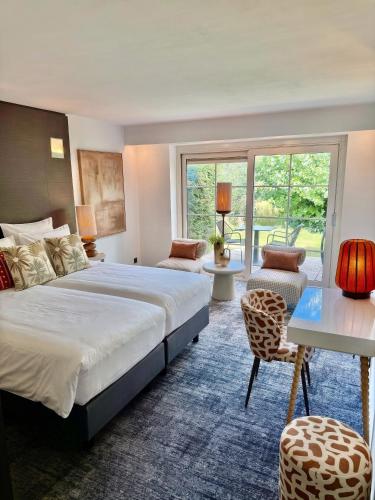 a hotel room with a large bed and a table at Van der Valk Hotel Gent-Drongen in Ghent
