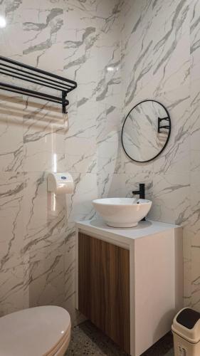 a bathroom with a white sink and a mirror at Patera Living in Sempidi