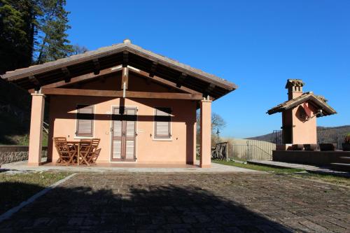 a small house with a porch and a cross at Il Casale Società Agricola Semplice di Barattini Pascucci Doriana e C in Pergola