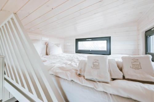 a white bed in a room with a window at Tiny Seaside - Kegnæs in Østerby