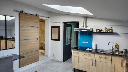 a kitchen with wooden cabinets and a sink at LE TRANSAT 40m de la plage in Palavas-les-Flots