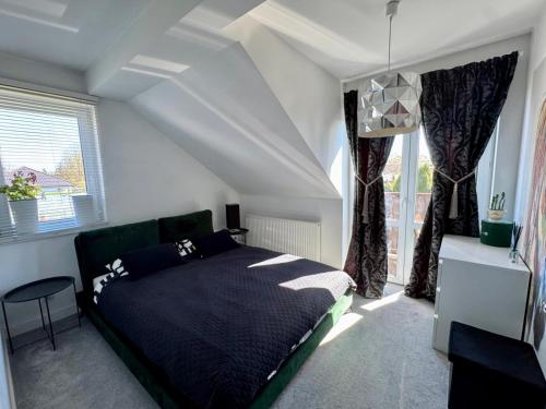 a bedroom with a bed in a room with windows at Apartament Polli in Grudziądz