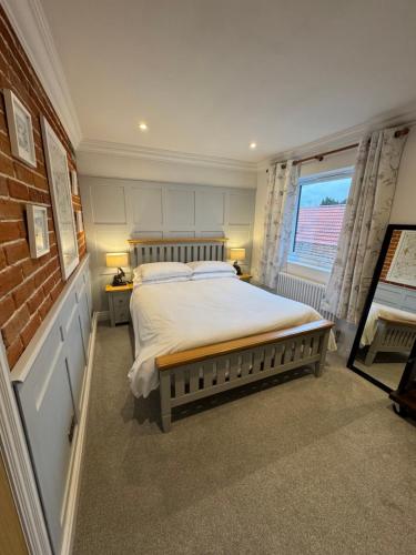 a bedroom with a large bed and a window at Hall Farm Cottage, Barham in Ipswich