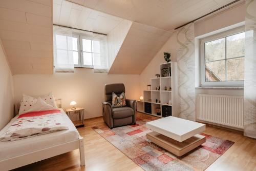 a bedroom with a bed and a chair and a table at Ferienwohnung Pietzavka in Wiesenfelden