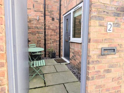 a patio with a table next to a brick building at The Mews with free parking in York