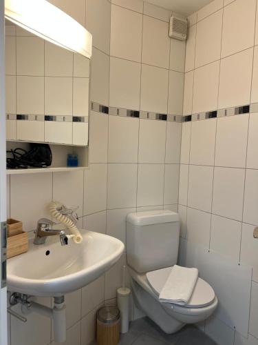 a white bathroom with a toilet and a sink at Rawda Ferien Wohnung in Interlaken