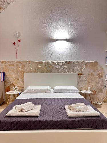 a bedroom with a bed with two towels on it at La Piccola Dimora in Giovinazzo