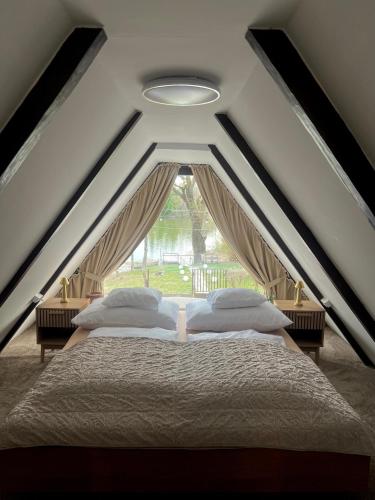 a bedroom with two beds and a window at LODKA Vendégház in Szigetcsép