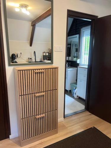 a room with a mirror and a kitchen with a door at LODKA Vendégház in Szigetcsép