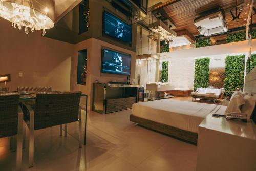 a hotel room with a bed and a dining room at Luna Blu Concept in Curitiba