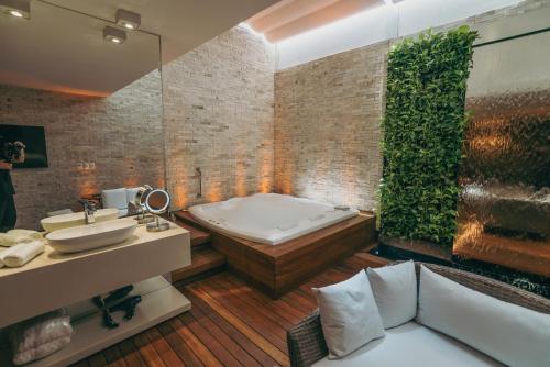 a bathroom with a bath tub and a sink at Luna Blu Concept in Curitiba