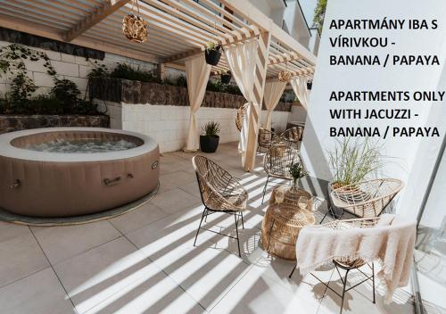 a patio with a hot tub and chairs and tables at JUMBO APARTMENTS in Rajecké Teplice