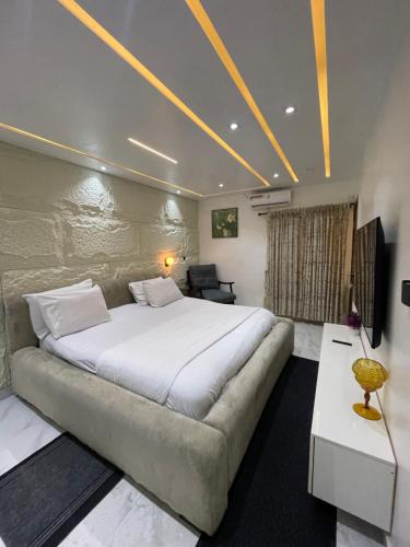 a bedroom with a large bed and a couch at Meenah luxury homes in Ikeja
