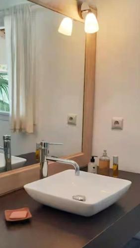 a white sink in a bathroom with a mirror at Villa Mouna in Poponguine