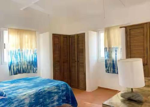 a bedroom with a bed and a table with a lamp at Villa Mouna in Poponguine