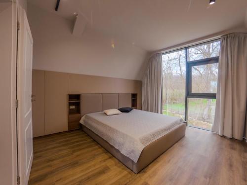 a bedroom with a large bed and a large window at Lotus 2 in Goruna