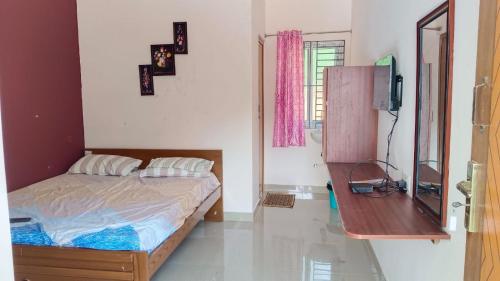 a bedroom with a bed and a tv in it at New Mountain Resort in Nāmakkal