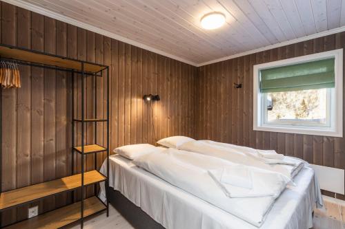 a bedroom with a bed in a wooden wall at Rauland Feriesenter in Rauland