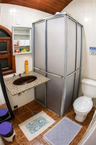 a small bathroom with a toilet and a refrigerator at Nova Perola de Guaruja in Guarujá