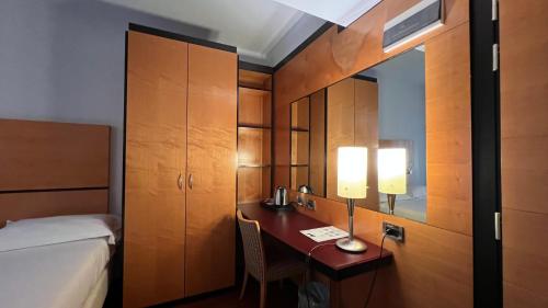 a hotel room with a desk with a bed and a bedroom at Hotel Igea in Brescia