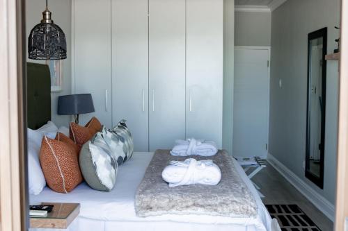 a room with a bed with two towels on it at Bay Lodge on the Beach in Mossel Bay