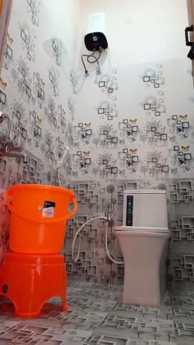a bathroom with an orange bucket and a toilet at New Mountain Resort in Nāmakkal