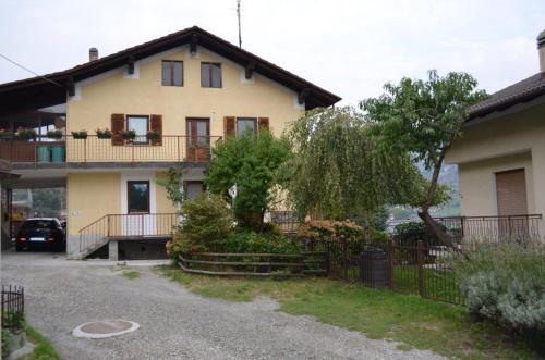 a large yellow house with a fence and a driveway at Camera Fenis in Fenis