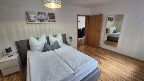 a bedroom with a large bed with white sheets and pillows at Ferienwohnung BungertOase in Saarburg