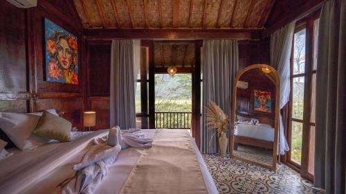 a bedroom with a large bed and a mirror at Nari Swari Sidemen in Karangasem
