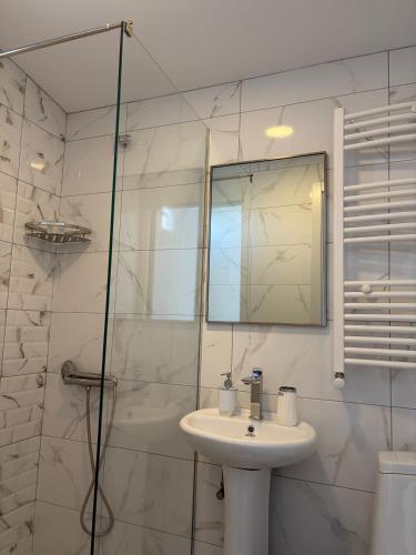a white bathroom with a sink and a shower at Panorama in Sighnaghi