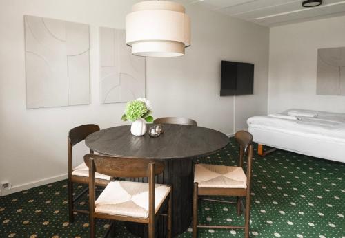 a room with a table and chairs and a bed at Faxe Ladeplads Motel in Hylleholt