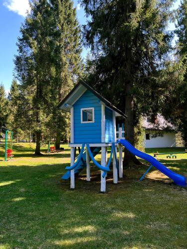 a playground with a blue house and a slide at Ośrodek Nad Potokiem in Poręba Wielka
