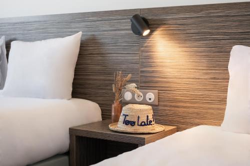 a bed room with two beds and a nightstand between two beds at Hôtel du Midi Plage in Palavas-les-Flots