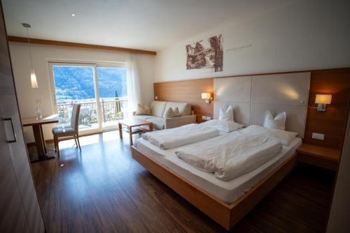 a bedroom with a large bed and a balcony at Apartments Oberdorner in Lagundo