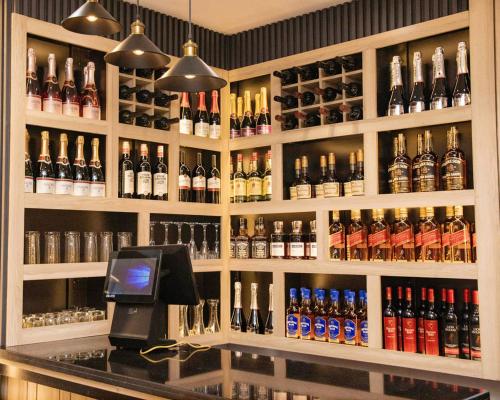 a bar with a lot of bottles of alcohol at Orchid - Bliss Hotels in Lagos